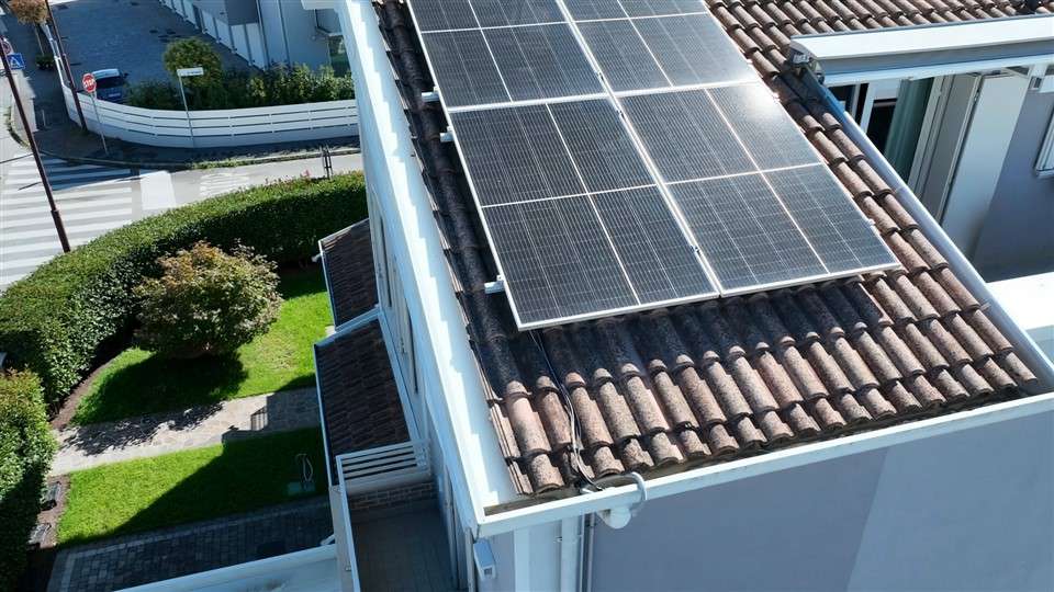 Vista ravvicinata di pannelli fotovoltaici e cornicione del tetto ripresa con drone durante un'ispezione