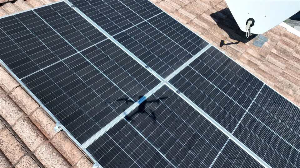 Ombra del drone proiettata su un pannello fotovoltaico durante la verifica ravvicinata dello stato della superficie
